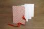 Preview: Leporello offen, Zieharmonika, heller Fotokarton, Blumencover modern in orange und rot, rotes Schleifenband